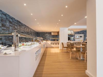 Moderne Hotelküche mit Buffet und Holzboden in einem hellen Speiseraum.