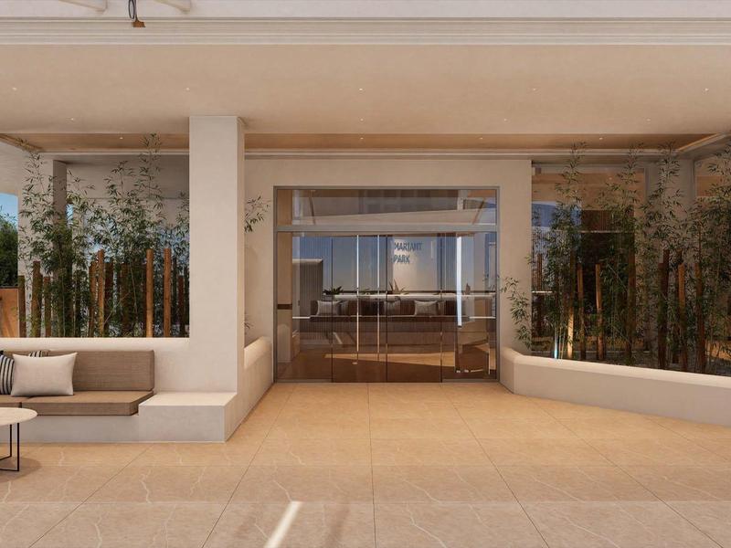 Taras z miejscem do siedzenia przed nowoczesną szklaną fasadą z widokiem do środka.