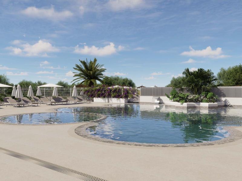 Okrągły basen z leżakami i roślinami pod słonecznym, lekkim zachmurzonym niebem