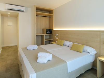 Modernes Hotelzimmer mit Doppelbett, minimalistischer Einrichtung und Klimaanlage.