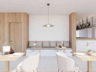 Minimalistischer Essbereich mit Holzakzenten und grauem Sofa in modernem Hotelinterieur.