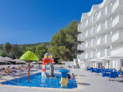 Hotel mit weißem mehrstöckigem Gebäude, Poolspielbereich und blauen Stühlen im Außenbereich.