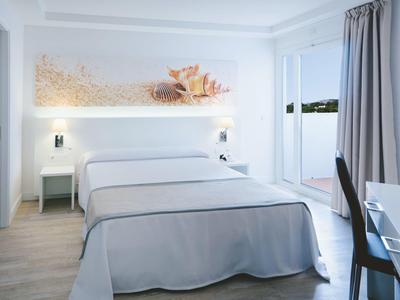 Nowoczesny pokój hotelowy z podwójnym łóżkiem, biurkiem, krzesłem i balkonem z widokiem na morze.