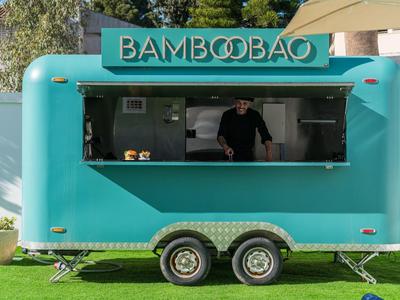 Türkiser Foodtruck mit dem Schild BAMBOOBAO und einer Person im Inneren.
