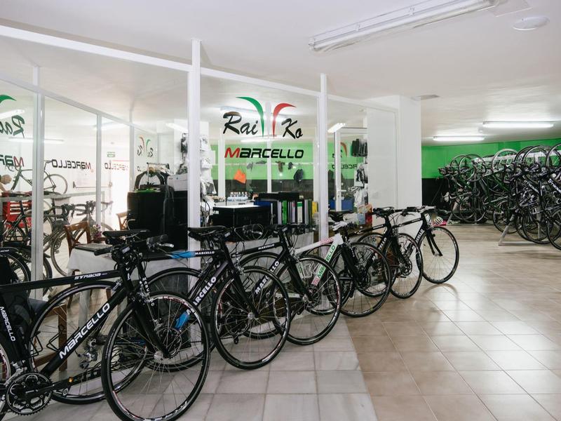 Nowoczesny pokój na rowery z wieloma rowerami i jasnymi kafelkowanymi podłogami w hotelu.