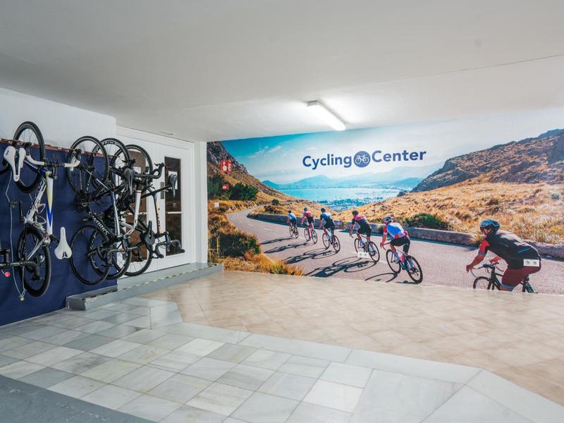 Przestrzeń wewnętrzna z muralem rowerzystów i powieszonymi rowerami w Cycling Center.