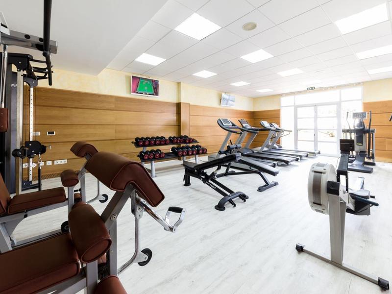 Palestra luminosa con attrezzature moderne e grandi finestre