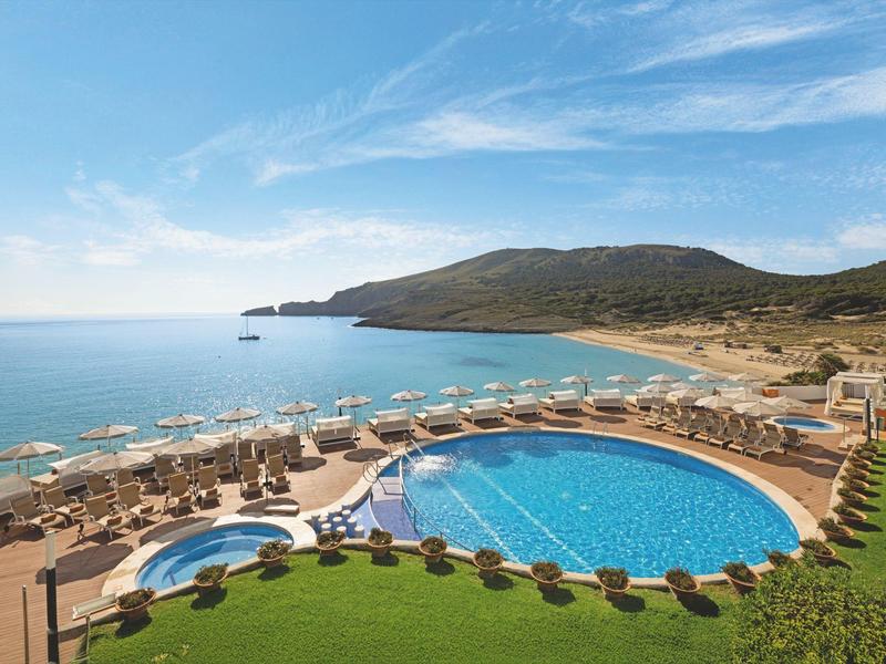 Grande piscina rotonda con vista sul mare e sul paesaggio circostante sotto un cielo azzurro