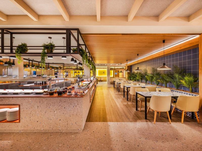 Ristorante moderno dell'hotel con area buffet e tavoli da pranzo arredati con stile