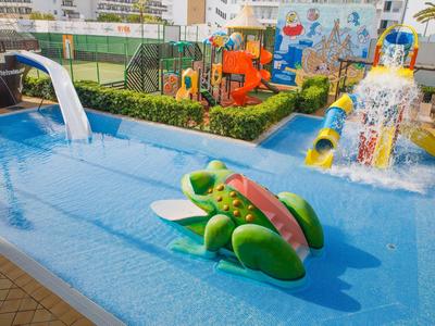 Kinderbecken mit Wasserrutschen und buntem Spielplatz in einem Hotel.