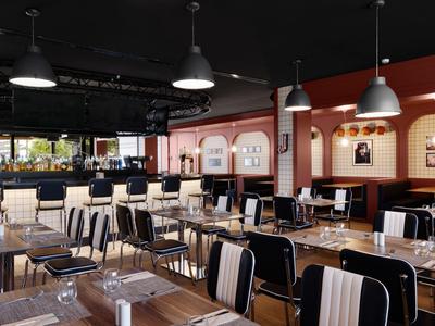 Modern eingerichtetes Restaurant mit Holztischen, Stühlen und großen Fenstern.