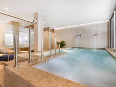 Moderner Wellnessbereich mit beheiztem Innenpool und bequemen Ruhezonen