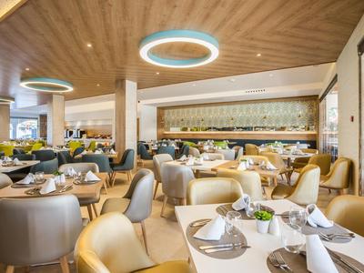 Modern eingerichteter Hotelrestaurant-Speisesaal mit gedeckten Tischen und Holzelementen.