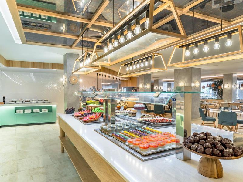 Moderní bufet s různými dezerty v elegantní hotelové restauraci.