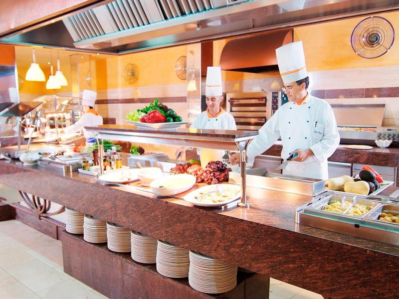 Köche bereiten ein abwechslungsreiches Buffet in einer Hotelküche vor.