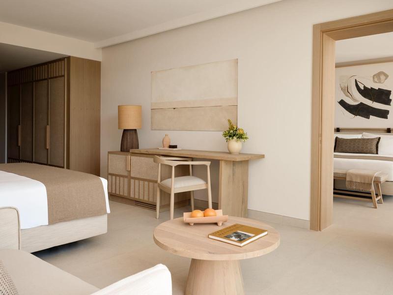 Jasne, nowoczesne pokoje hotelowe z dwoma łóżkami i ciepłymi drewnianymi akcentami.