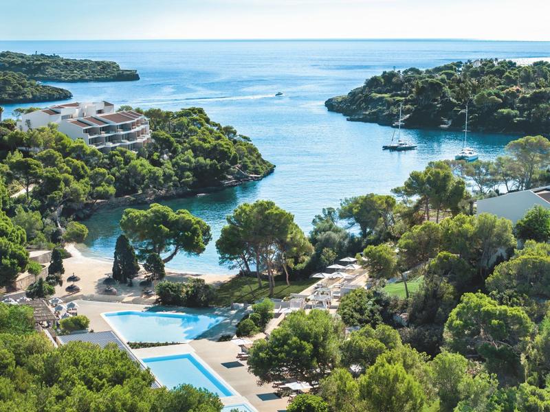 Widok na zatokę przybrzeżną z zalesionymi wzgórzami i basenem.