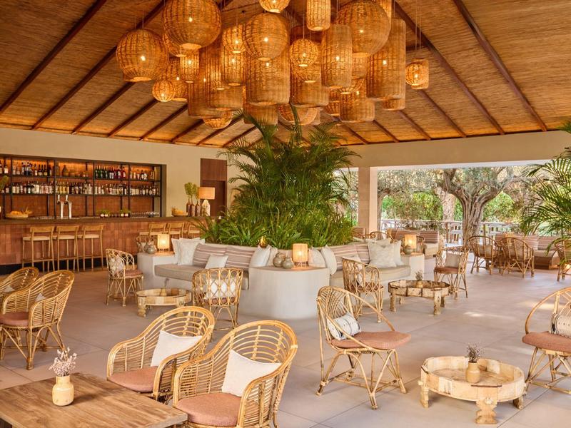 Jasny teren zewnętrzny z meblami rattanowymi i barem pod drewnianym sufitem