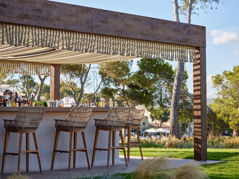 Nowoczesna przestrzeń na zewnątrz z barem i miejscami do siedzenia w ogrodzie na słońcu.