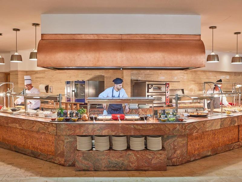 Buffet area with chef behind counter and various dishes in a hotel restaurant.