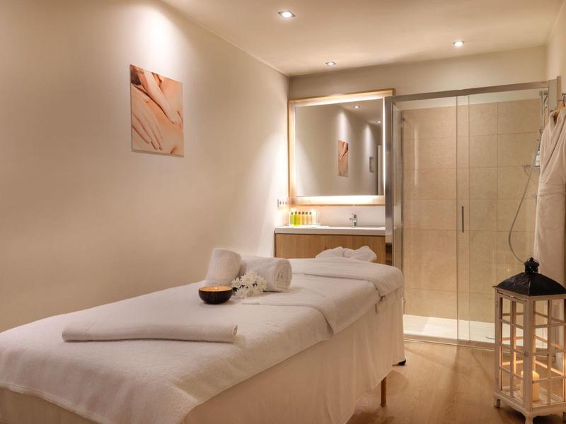 Salle de massage confortable avec table de soin, éclairage doux et ambiance relaxante.