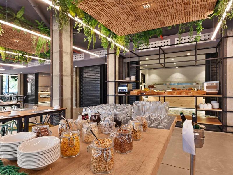 Moderní snídaňová část s bufetem a dřevěnými stoly v hotelu.