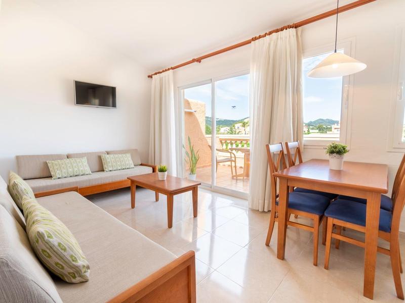 Nowoczesna siłownia z rowerkiem treningowym, bieżnią i orbitrekiem pod drewnianym stropem.