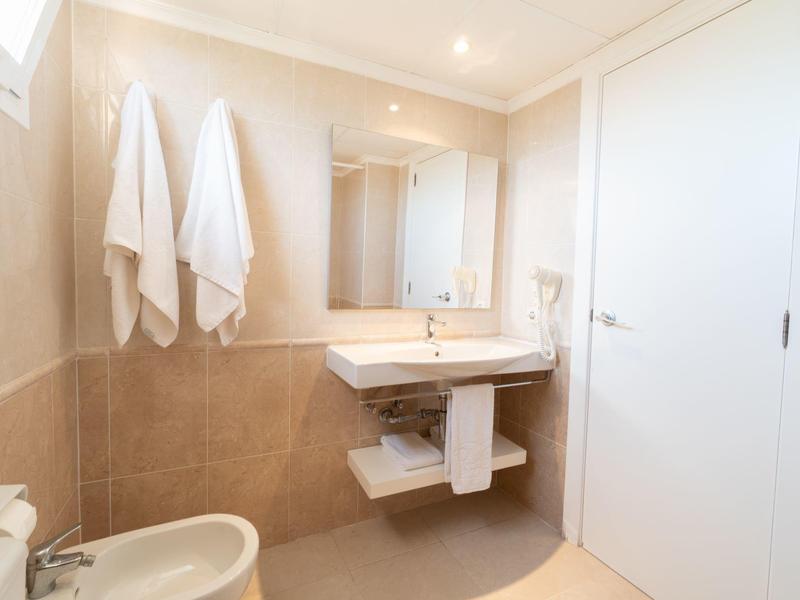 Nowoczesna łazienka z umywalką, ręcznikami i toaletą w neutralnych kolorach.