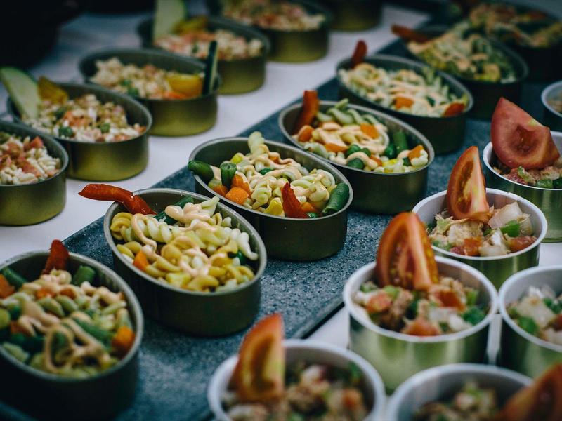 Varias tazas con ensalada mixta servidas para un buffet o catering en el hotel.
