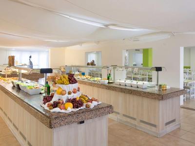 Buffetbereich mit Obst, Getränken und Speisen in modern gestaltetem, hellem Raum.