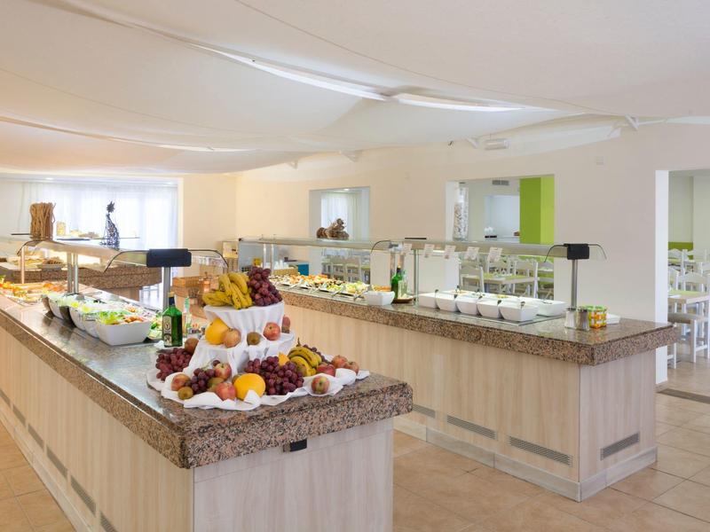 Buffet lumineux avec fruits frais et divers plats dans un restaurant d'hôtel moderne.