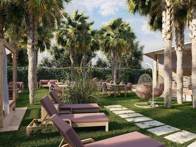 Espace piscine avec chaises longues, palmiers et fauteuil suspendu en plein air au soleil.