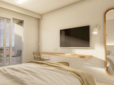 Chambre d'hôtel moderne avec un grand lit, une télévision murale et un grand miroir.