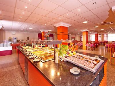 Buffet luminoso con piatti vari assortiti in una grande sala da pranzo.