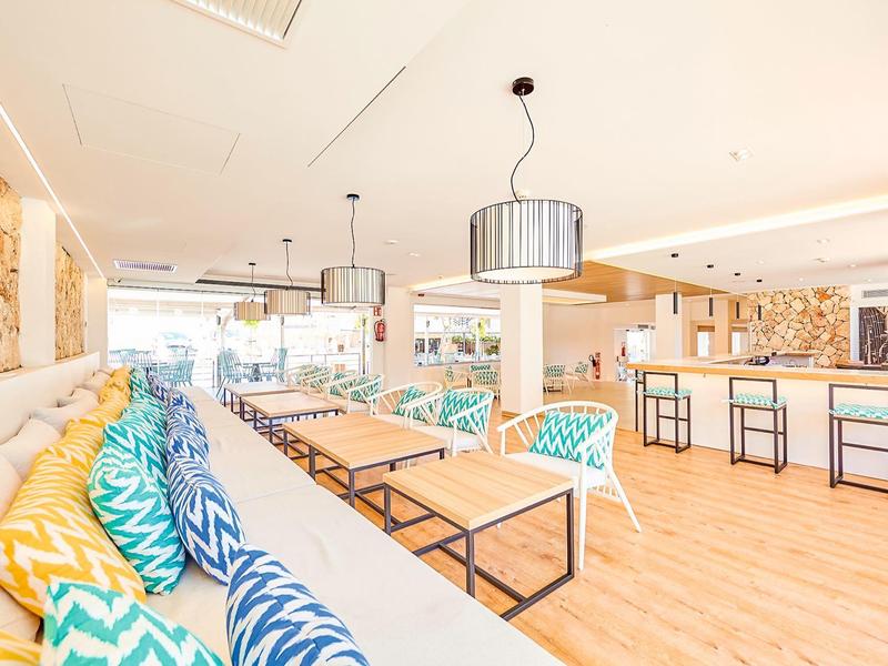 Bright hotel lounge area with colorful cushions and modern tables