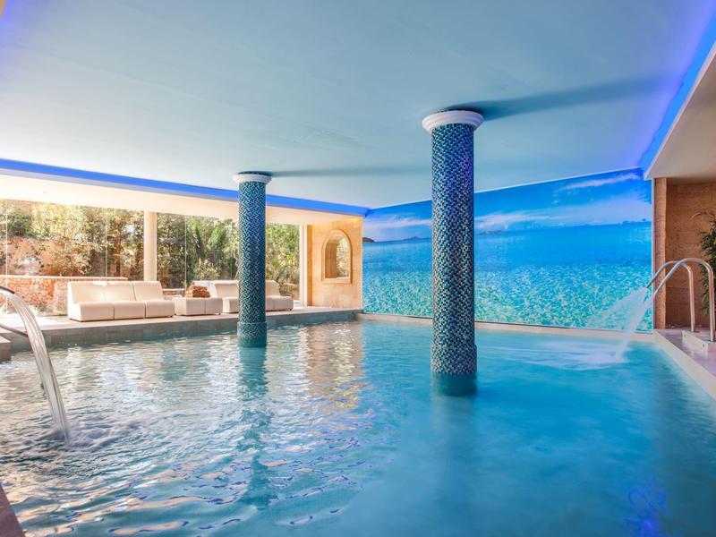 Modern indoor pool with columns and relaxing atmosphere in a hotel.