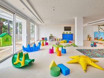 Heller, großzügiger Spielbereich mit Buntspielzeug und großen Fenstern zum Außenbereich.