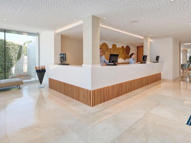 Hell erleuchteter Hotel- Empfangsbereich mit Marmorfußboden und moderner Einrichtung.