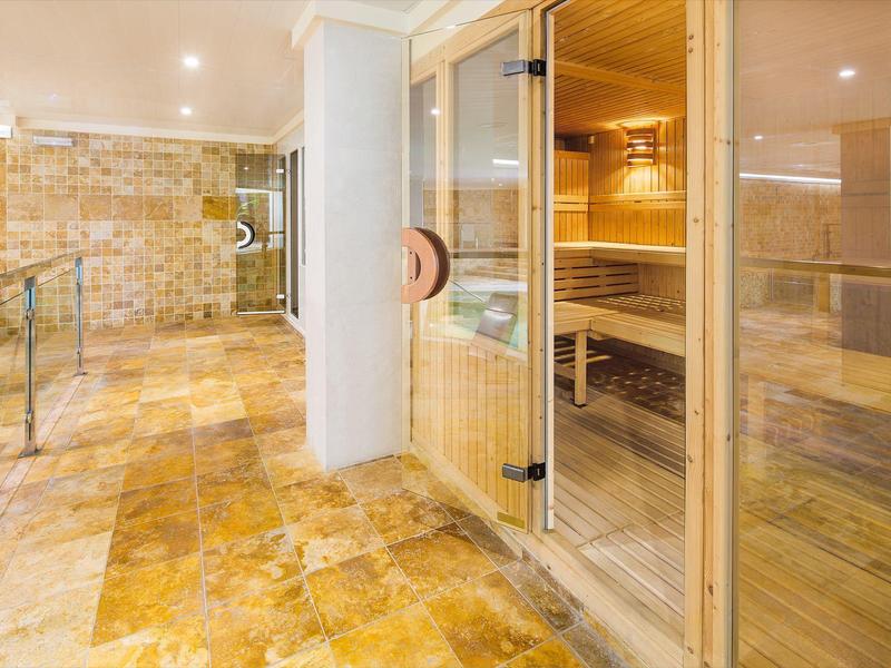 Modern wellness area with sauna and marble tile flooring.