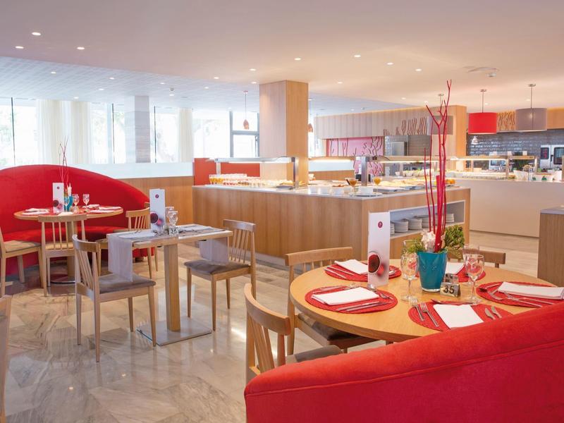 Ristorante dell'hotel luminoso con panche rosse e mobili moderni.