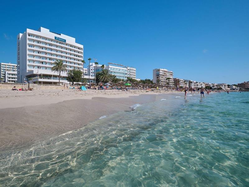 Helder water en zandstrand voor moderne hotels op een zonnige dag.