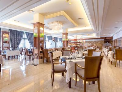 Elegante ristorante dell'hotel con mobili in legno e tavoli apparecchiati.