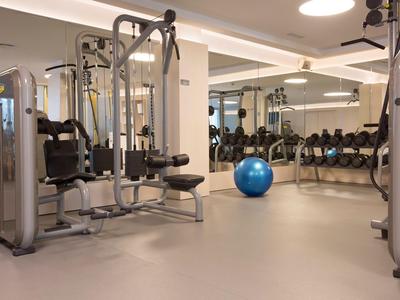 Salle de sport moderne avec machines de musculation et haltères dans un hôtel.