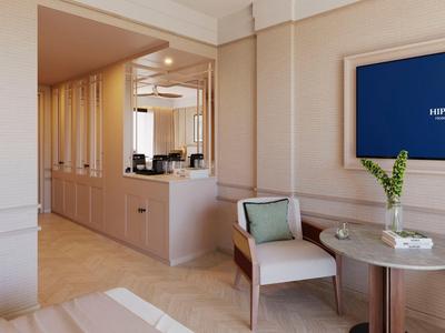 Een elegant hotelkamergebied met zithoek, decoratieve tafel en uitzicht op de keuken.