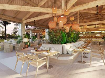 Terrasse de restaurant lumineuse et ouverte avec mobilier en bois et coins salon confortables au design naturel.