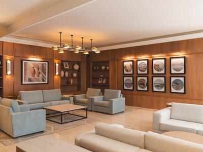 Moderne hotel lobby met comfortabele banken, houten lambrisering en kunstwerken aan de muren.