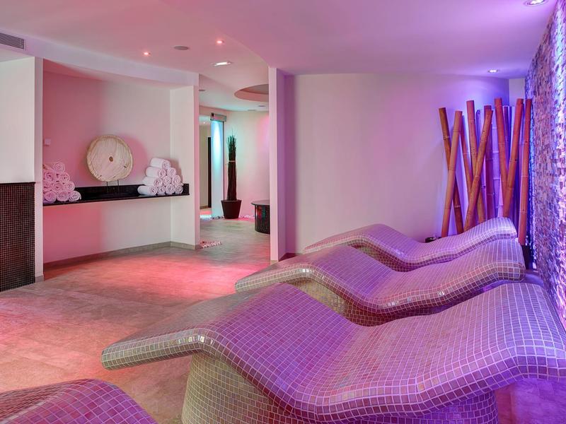 Sala relax con sedie a sdraio curve e illuminazione viola rilassante.