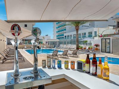 Moderne Hotelbar mit Bierzapfanlage, verschiedenen Biersorten und Poolblick