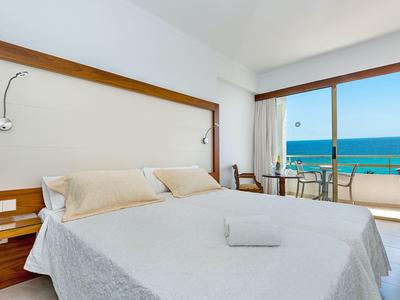 Helles Hotelzimmer mit Doppelbett, Balkon und Meerblick
