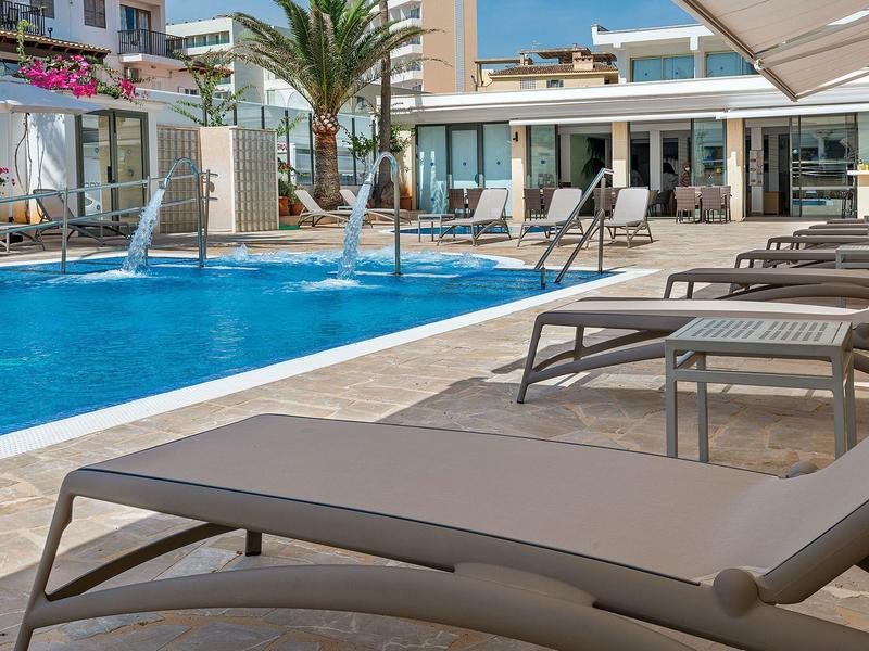 Poolbereich mit Liegestühlen und Sonnenschirmen neben einem modernen Hotelgebäude